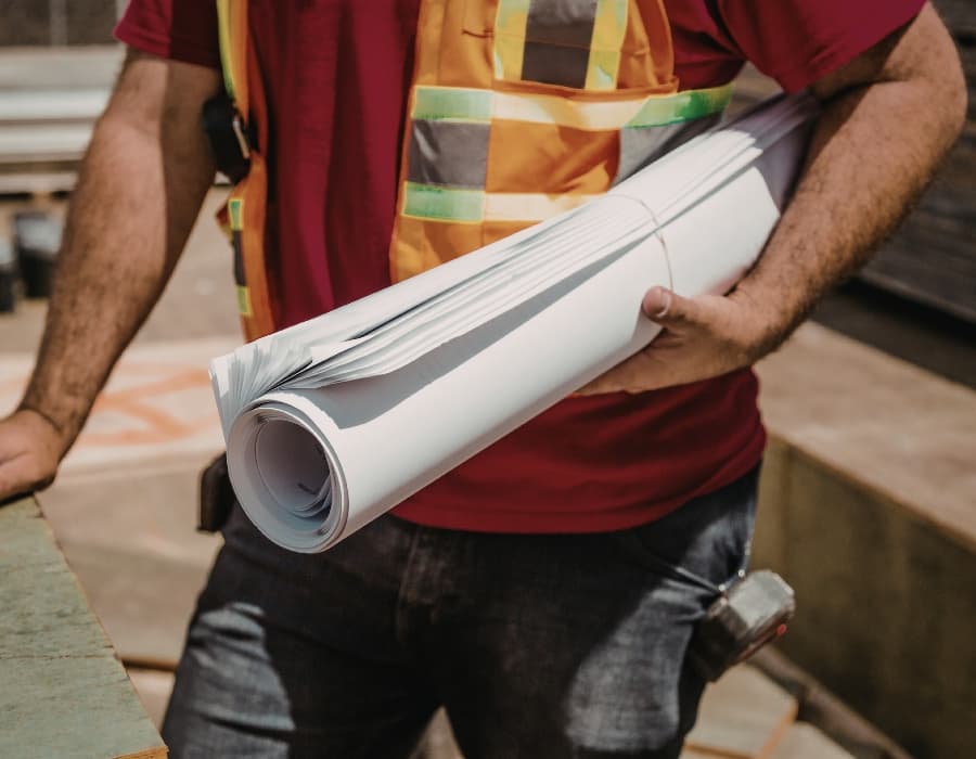 Construction worker with blueprints on a building site